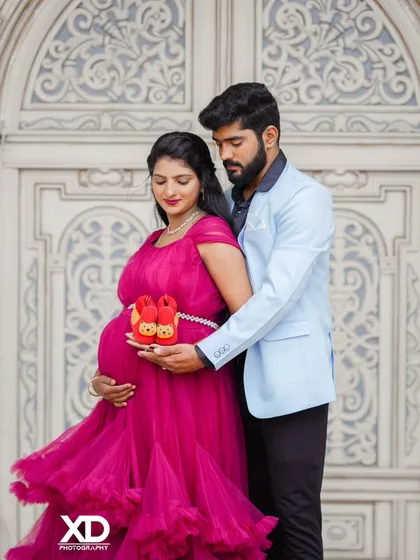 A close-up on the details, with the couple holding adorable baby shoes against the baby bump.