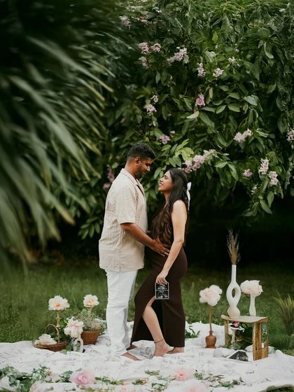 A standing portrait in a beautiful garden, with the couple surrounded by flowers and greenery.