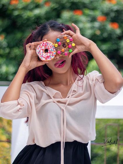 'Peek A Boo!' Using colorful donuts as playful props for a fun and sweet portrait. This kind of shoot is perfect for capturing a joyful and lighthearted personality.