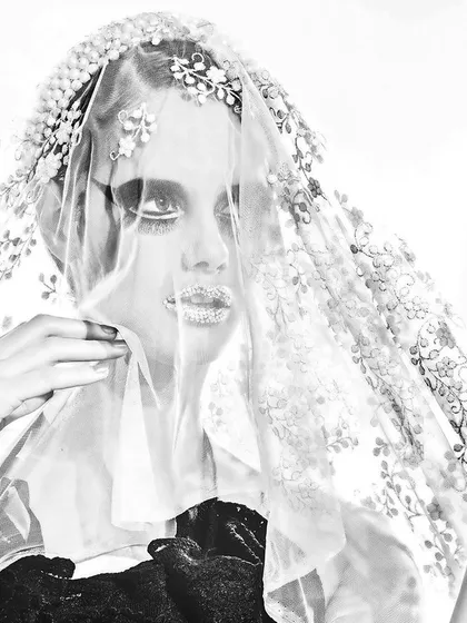An artistic, high-contrast fashion portrait. For this creative shoot, we used a delicate lace veil and dramatic makeup with crystal-adorned lips to create a memorable and avant-garde image.