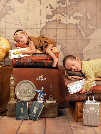 Tired out from their long journey. This adorable shot shows the twin travelers sleeping on vintage suitcases, a perfect ending to their world tour photoshoot.