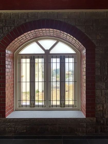 A close-up of the arched window, highlighting the texture of the stone and brick.