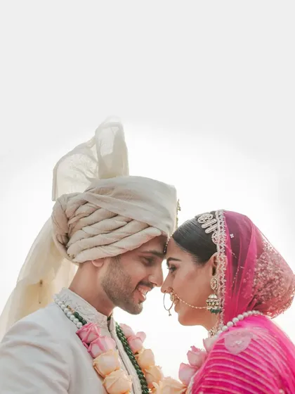 An intimate close-up of the couple, their foreheads touching, silhouetted against a bright sky.
