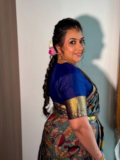 Ashwini's evening look for her Gruhapravesha. We created a brown smokey eye and a messy braid with a lotus flower to enhance the look.