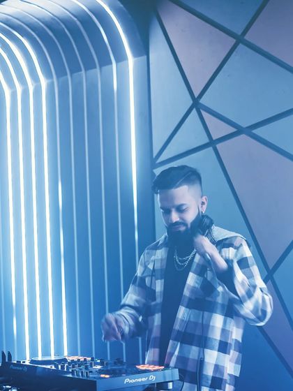 The harder the conflict, the more glorious the triumph. A shot of me at the console against a cool, geometric blue-lit background.