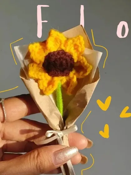 A close-up of the mini crochet sunflower, a perfect little burst of sunshine that you can hold in your hand.