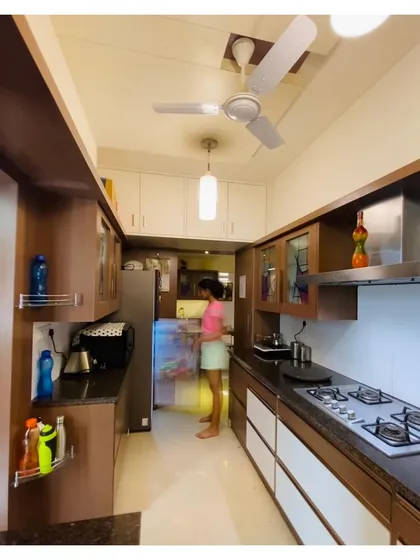 This view showcases the practical layout of the kitchen, with ample counter space, overhead storage, and designated spots for all appliances.