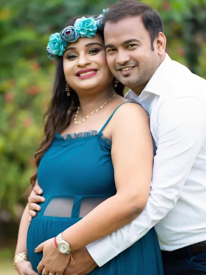 A bright and cheerful outdoor couple's portrait. Their smiles and the sunny garden setting create a photo that is full of life and happiness.