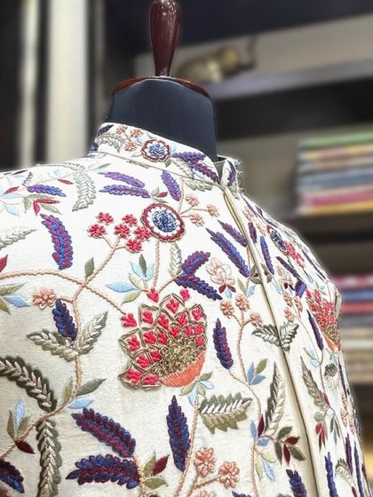 The dense, multi-color floral embroidery on this jacket is a testament to the skill of our artisans, creating a vibrant and festive piece.