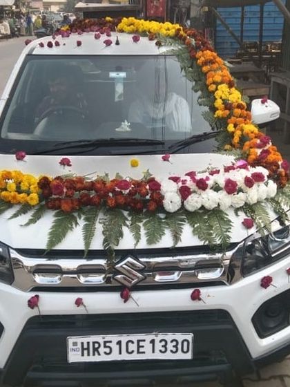 A classic car decoration on a white Maruti Suzuki Brezza. I used garlands of marigolds and roses on the bonnet and roof for a traditional wedding look.