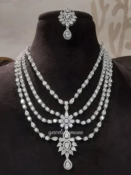 A magnificent multi-layered diamond necklace with a matching maang tika. This bridal piece is designed to create a cascading effect of sparkle, offering a look of unmatched grandeur and opulence.