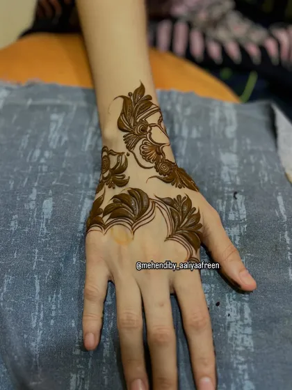 A simple and elegant leaf-based design on the back of the hand, perfect for a minimalist look.