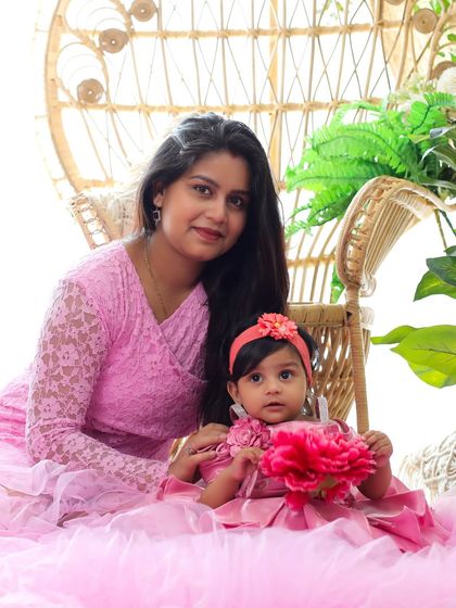 A sweet mother-daughter moment in our bright, bohemian studio setup. Dressed in matching shades of pink, they create a cheerful and loving portrait.