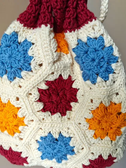 The colorful starburst granny squares on this potli bag make it a real statement piece. Each square is stitched with care.