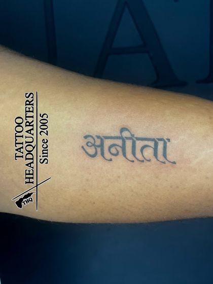 The name "Anita" tattooed in a clean and beautiful Devanagari (Hindi) script on the forearm.