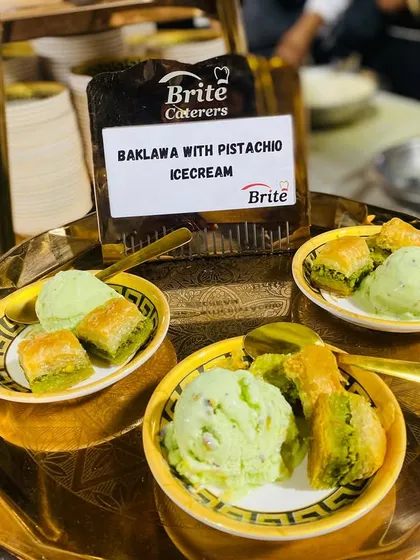 Three servings of Baklava with Pistachio Ice Cream, beautifully presented on a golden tray.