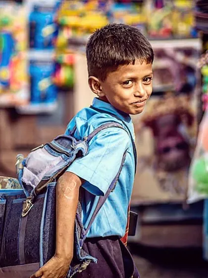 A candid shot of a schoolboy walking through a market in Hampi. That fleeting glance over his shoulder tells a whole story. I believe the best portraits are found in these everyday moments, capturing the genuine spirit of people's lives.