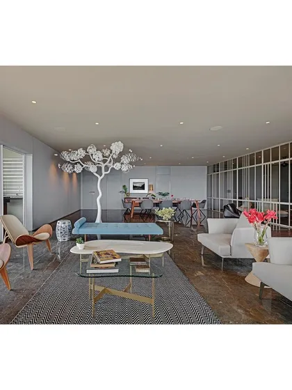 Art is fundamental to my design process. In this residence, I commissioned a stunning tree sculpture from artist Gopinath S, where each ceramic leaf was individually crafted. It serves as the central artistic statement in this open-plan living and dining area.