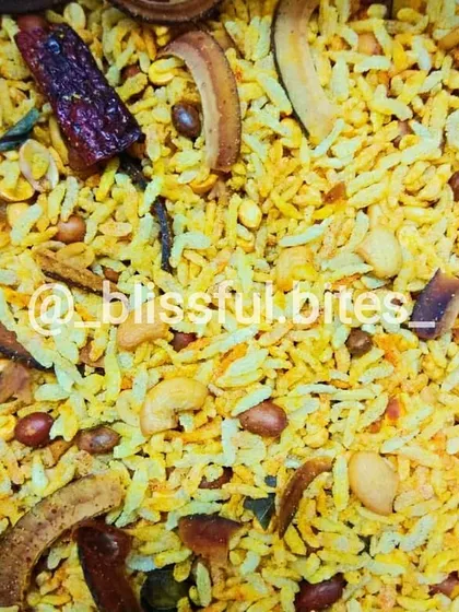 A close-up of my authentic, homemade Memon Chivda. This crunchy, savoury snack mix is made with flattened rice, nuts, and spices, perfect for tea time or as a party nibble.