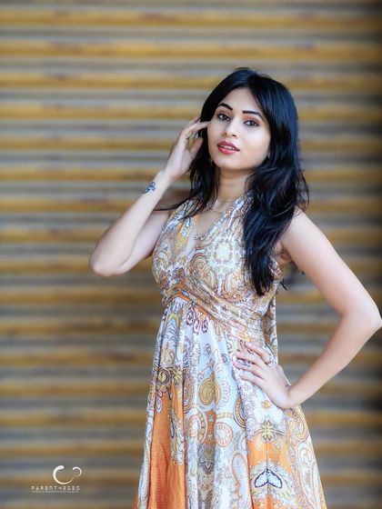 A beautiful half-body portrait against a textured wooden background. Her expression is soft and engaging.