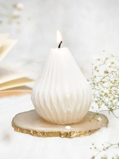 Our pear-shaped candle, lit and glowing on a beautiful agate coaster. Christmas is right around the corner.