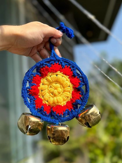 A bold and beautiful ghungroo hanging in primary colors of red, yellow, and blue. It's a striking piece that is full of energy.