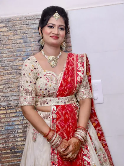 A close-up portrait showing the soft, glowing makeup and traditional jewellery.