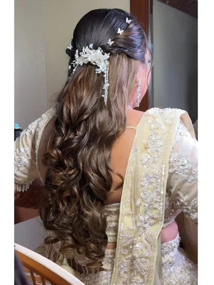 A view of the stunning reception hairstyle, featuring long, flowing curls and a delicate butterfly hair accessory.