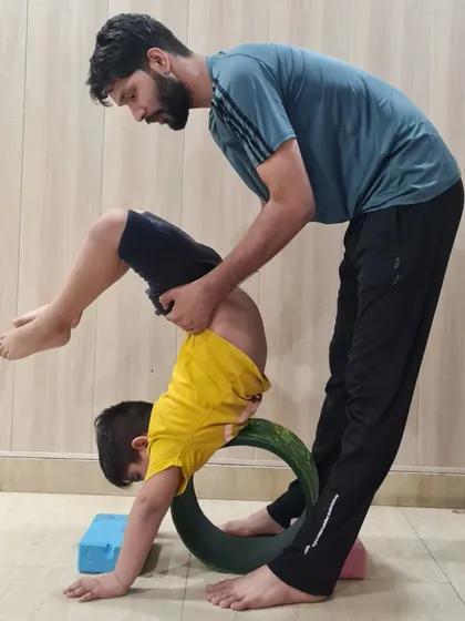 Safety and proper alignment are my top priorities in kids' yoga. Here, I am assisting one of our young yogis in a backbend using a yoga wheel, helping him build strength and flexibility in a controlled and supportive way.