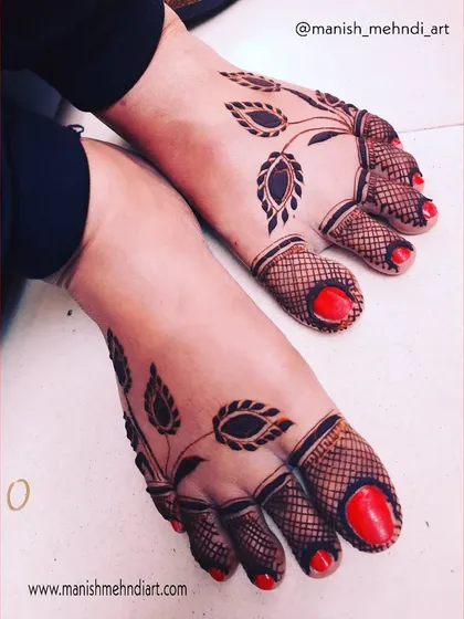 A simple yet bold design for the feet. This pattern uses negative space and leafy motifs to create a striking look, complemented by the dark-tipped toes.