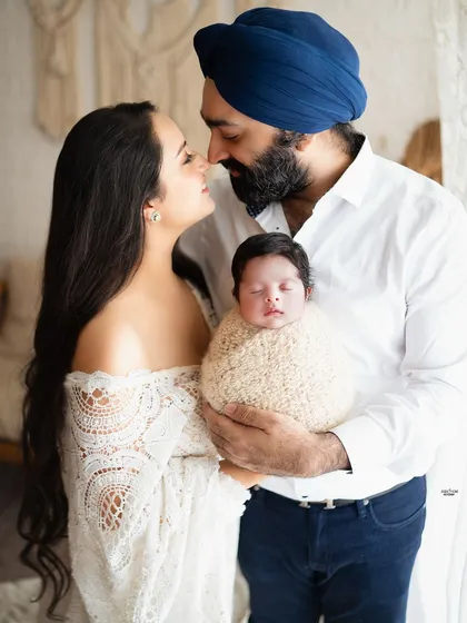 A classic portrait of new parents with their newborn, capturing the love and awe of this special time.