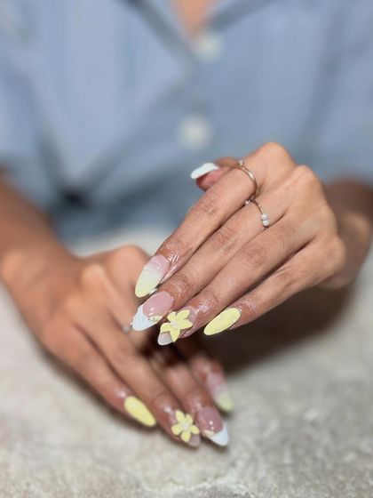 A fresh, summery look with pale yellow tips and delicate 3D flowers. This design is perfect for clients looking for something cheerful and seasonal.