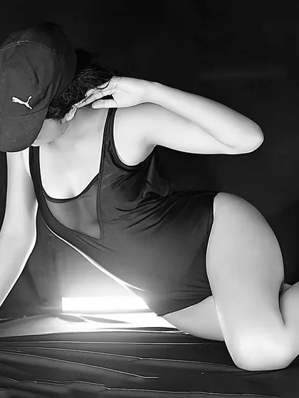 Adding a simple prop like a baseball cap can completely change the vibe of a shoot. This black and white image has a cool, street-style edge while still being a bold and sensual portrait.