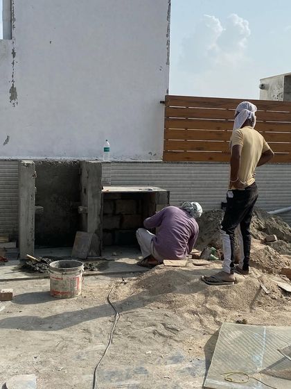 Building from the ground up. This image shows the initial stages of constructing a built-in feature on a terrace, with our team working on the concrete and brick foundation.