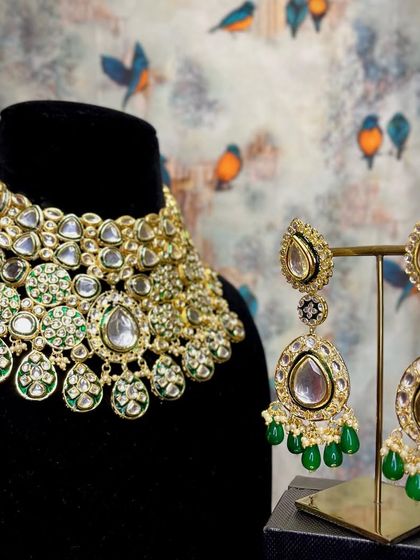 Sparkle on your wedding day with this exquisite Kundan necklace and earring set. The green Meenakari detailing adds a touch of classic elegance.