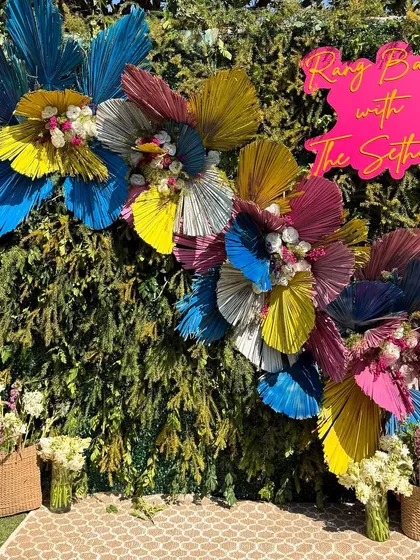 We love bringing a modern, playful twist to traditional festivals. For this Holi party, we designed a vibrant photo backdrop using colorful dried palm leaves and fresh flowers, creating the perfect spot for guests to capture the joy of the celebration.