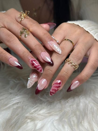 A beautiful and complex set featuring deep red French tips, velvet-effect nails, and pearly white accents.