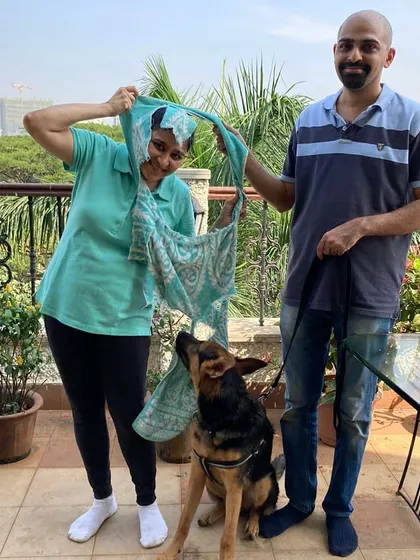 A fun, candid moment with clients and their German Shepherd after a training session. Laughter and play are essential parts of learning.