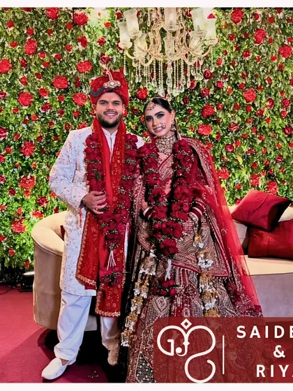 Standing before a wall of red roses, this couple radiates happiness. It is my utmost delight to witness this joy as they embark on their journey together.
