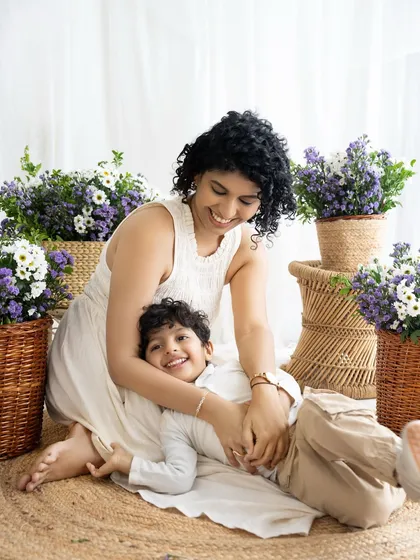 A playful and candid moment between mother and son. Lying on a soft rug, they share a laugh, capturing the fun and easygoing nature of their bond.