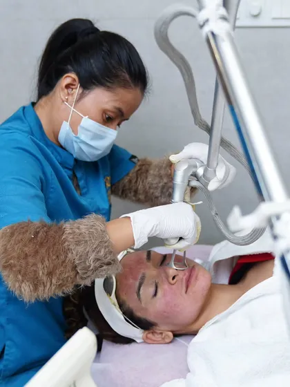 Here you can see our expert therapist performing a fractional laser treatment. This advanced, US-FDA approved technology is one of our primary tools for treating concerns like acne scars, fine lines, and uneven skin texture by stimulating collagen deep within the skin.