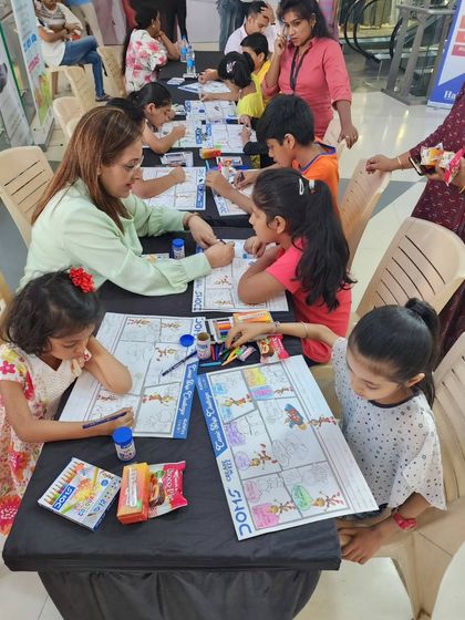 Here I am guiding a table of enthusiastic young artists at our Haiko Mall workshop. I love interacting with the children and helping them bring their ideas to life.