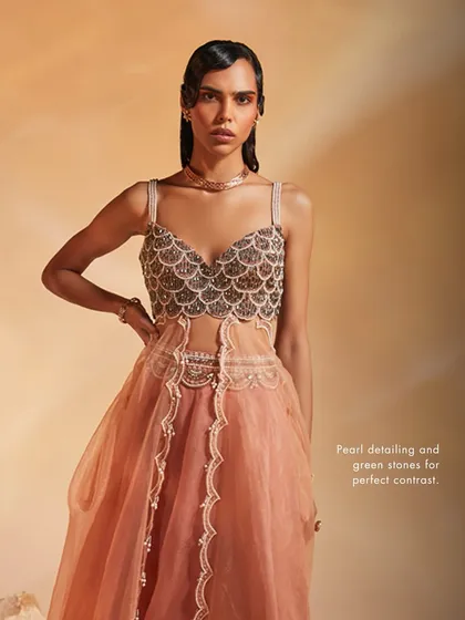 The Arlo Co-ord Set, where pearl detailing and green stones create a perfect contrast against the soft peach fabric and unique silhouette.