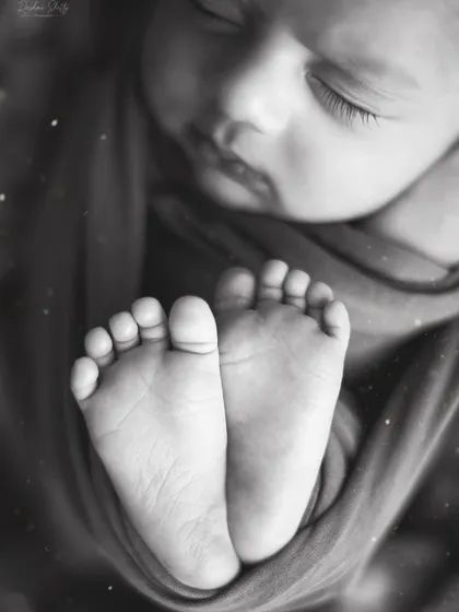 The same adorable feet, presented in a classic black and white edit. Monochrome photos offer a timeless, artistic quality that focuses on the form and texture of your baby's tiny features.