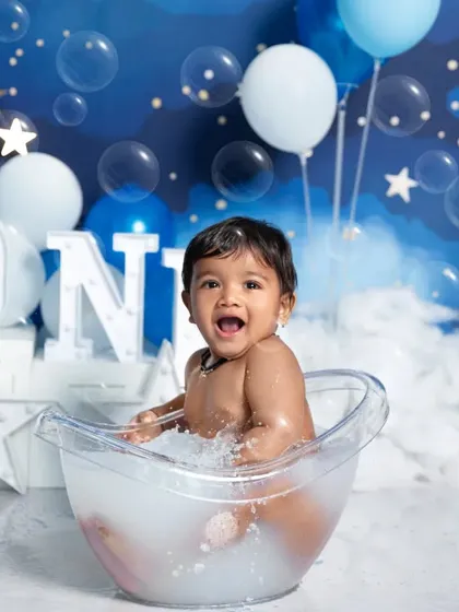 Pure joy during a first birthday bath splash! This add-on session captures the happiest moments as your baby plays in the water against a dreamy, starry night backdrop.