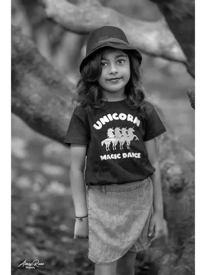 A confident pose from the seven-year-old birthday girl, captured in a classic black and white portrait. Her direct gaze and stylish hat make for a strong, memorable image.