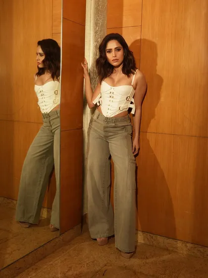 A full-length standing pose that showcases the contrast between the edgy corset top and the casual denim.