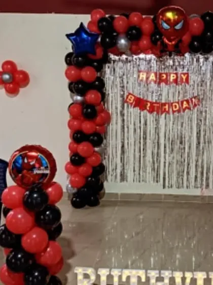 A compact Spiderman theme with a balloon arch and pillars against a silver tinsel backdrop, perfect for smaller venues.