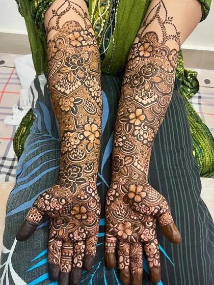 A full view of a recent bridal mehndi, with dense floral patterns covering the hands and arms.