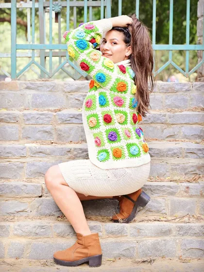 A model showcasing our vibrant floral granny square jacket. This piece is a favorite, combining a classic crochet pattern with a burst of modern, joyful colors.